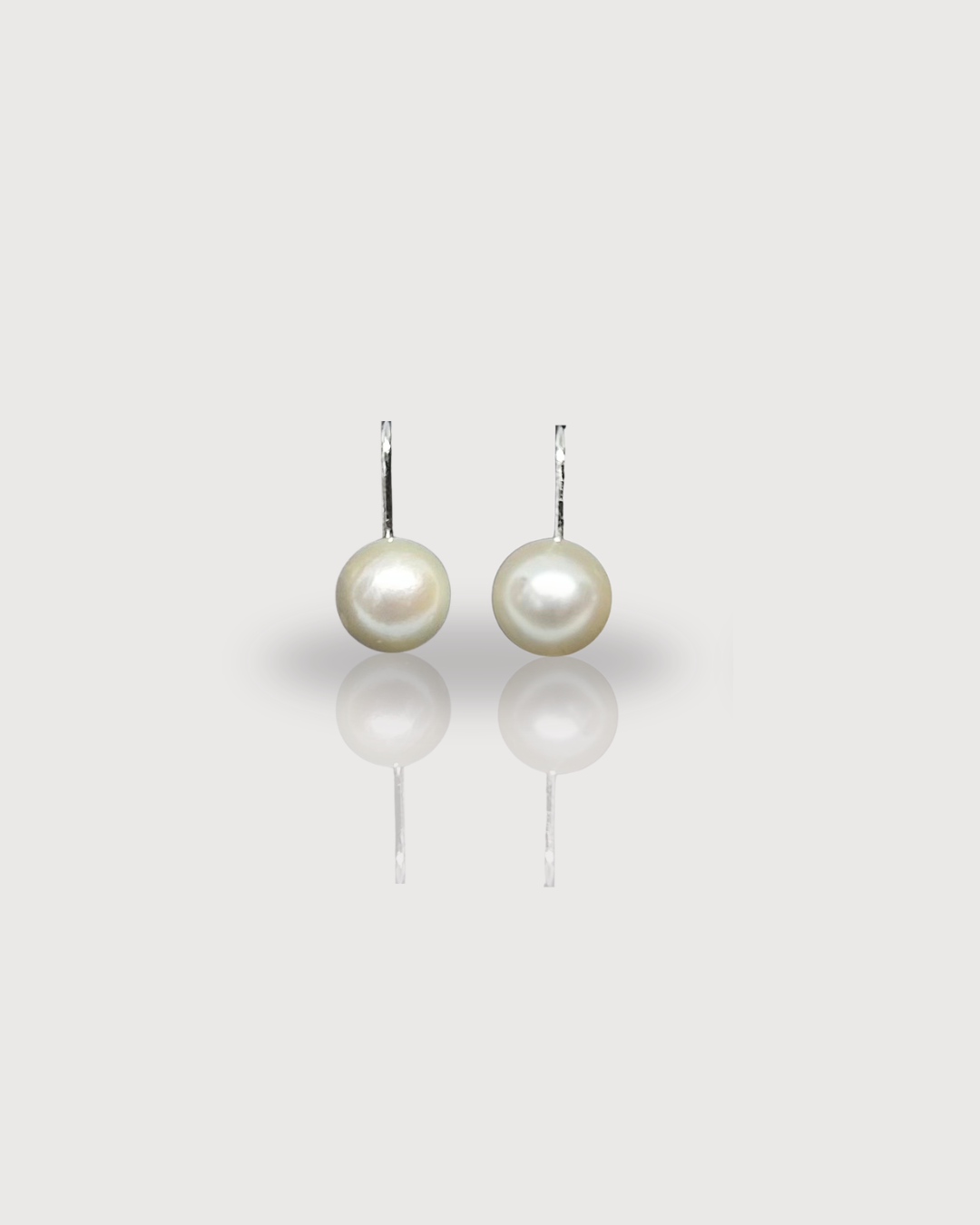 Pair of pearl earrings on a light gray background